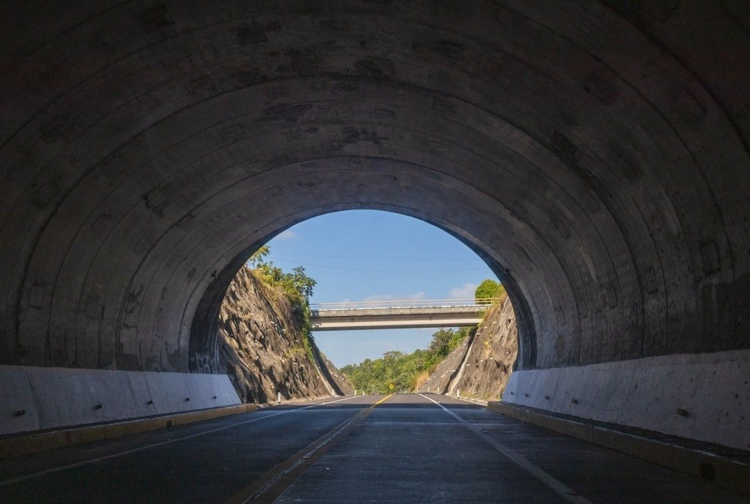 Weg door een betonnen tunnel met een viaduct en groen aan de uitgang